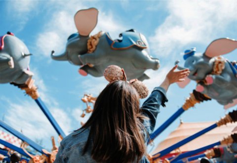 Little Girl Waving At Guest Riding Dumbo the Flying Elephant at Magic Kingdom