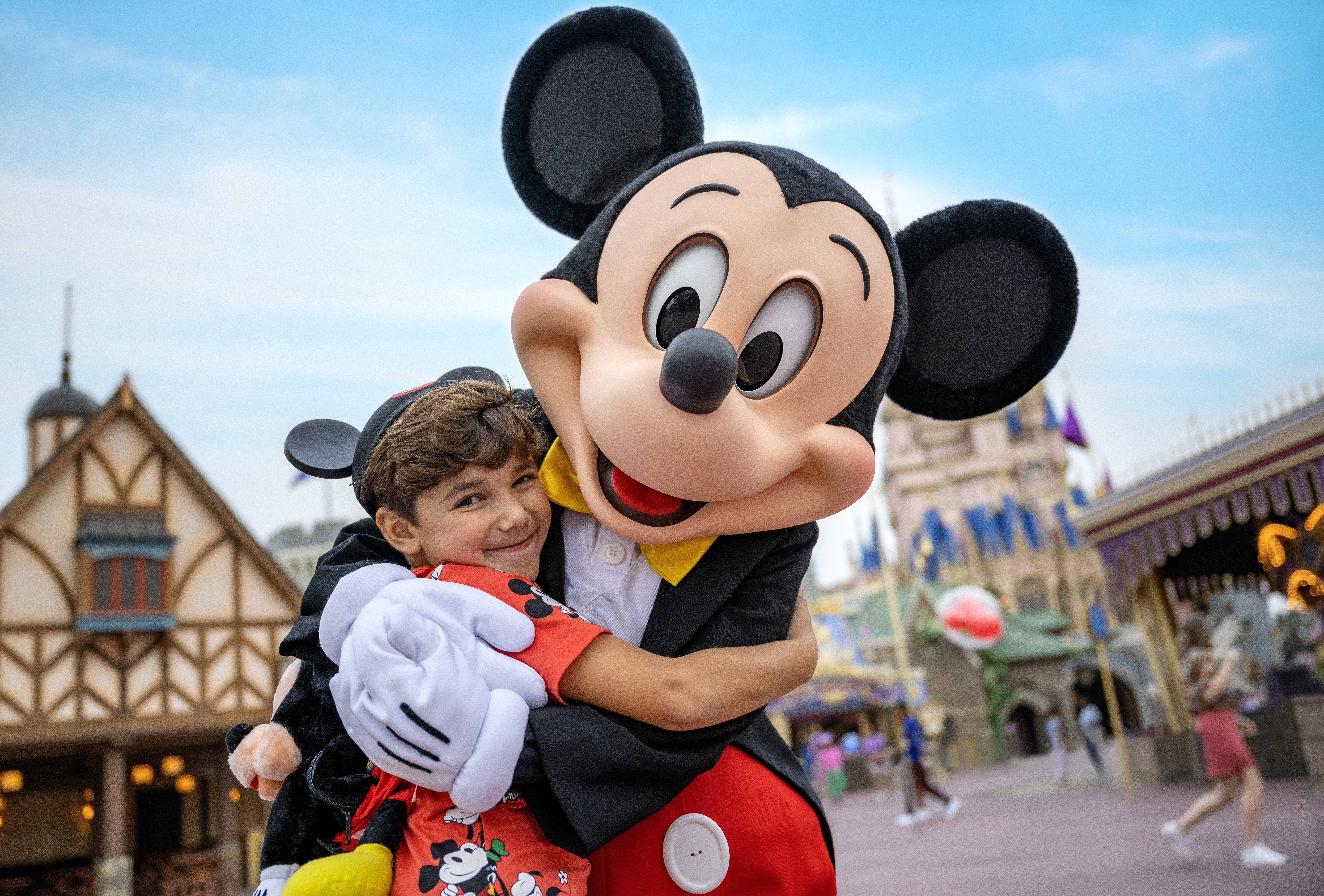 Mickey Mouse Hugging a Small Boy Wearing Mickey Ears