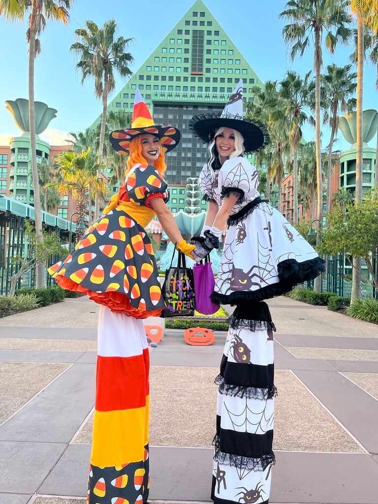 Girld on stilts dressed in Halloween costumes