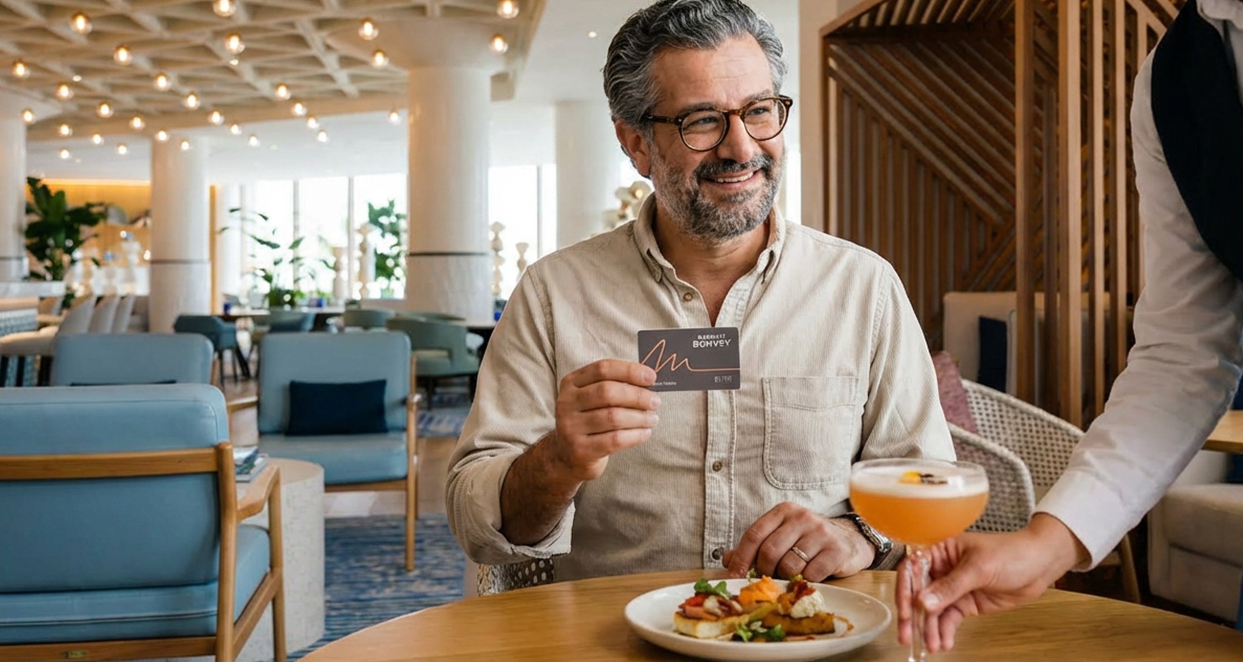 Ein Marriott Bonvoy-Mitglied hält seine Mitgliedskarte an einem Restauranttisch in der Hand