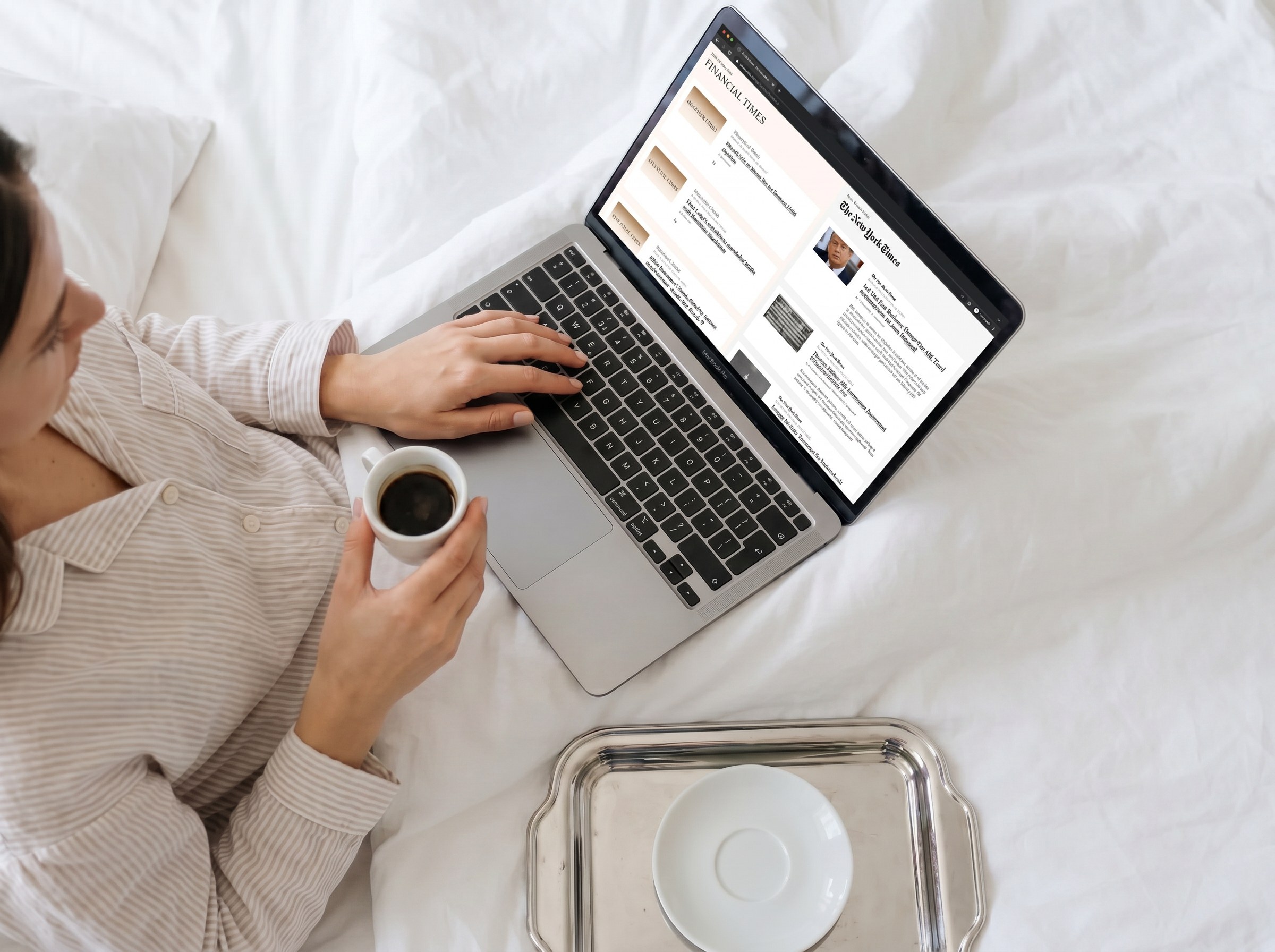 An open laptop beside a breakfast tray on a hotel bed