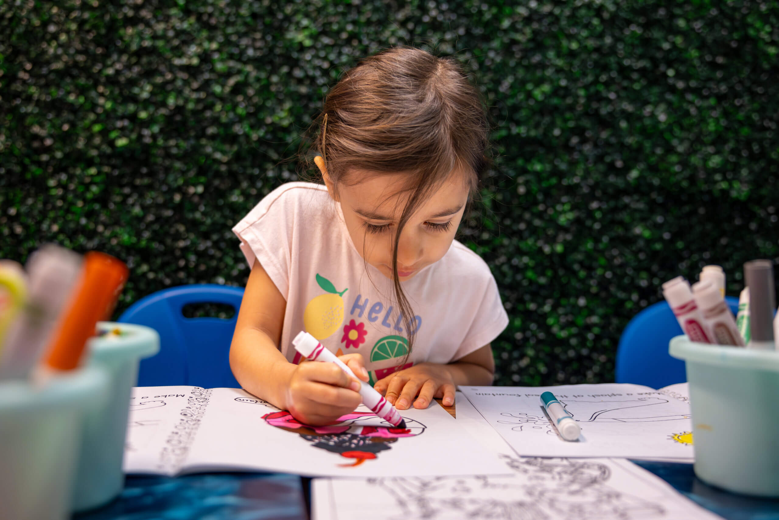 Little girl coloring with magic markers at Camp Dolphin Kids Camp.