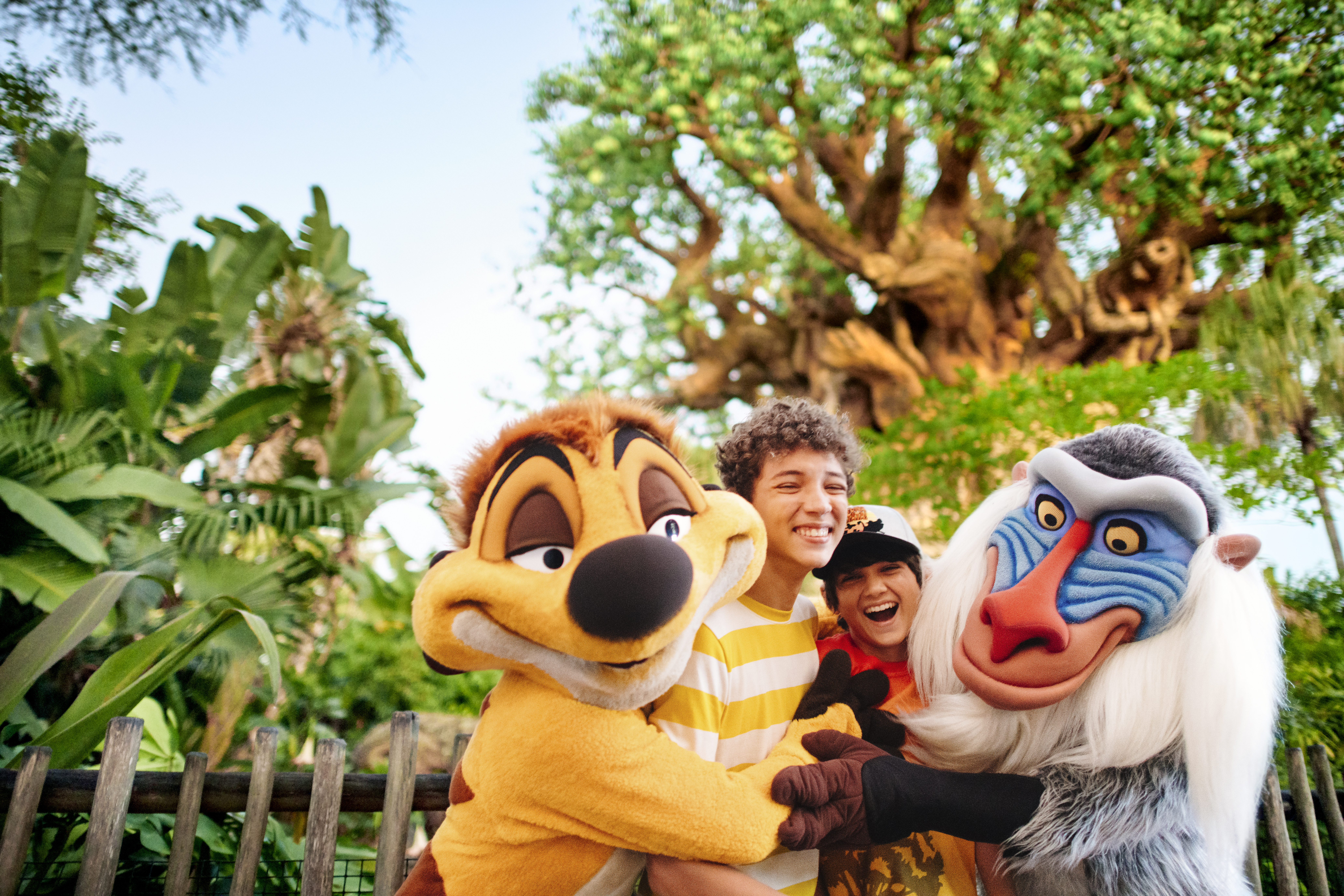 Two boys being hugged by Disney characters.